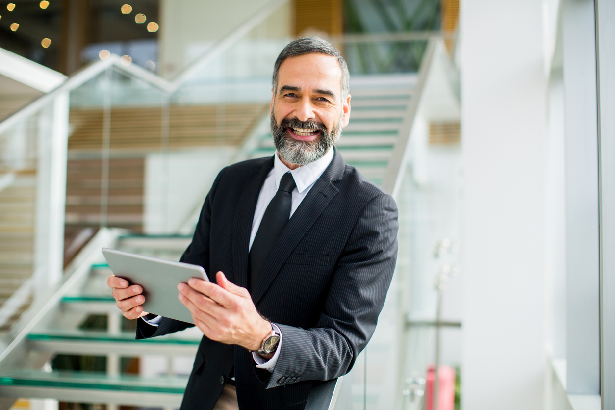 Smiling businessman using a tablet device while managing his business property.